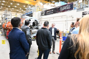 One man speaking to a crowd in a large nuclear physics facility 